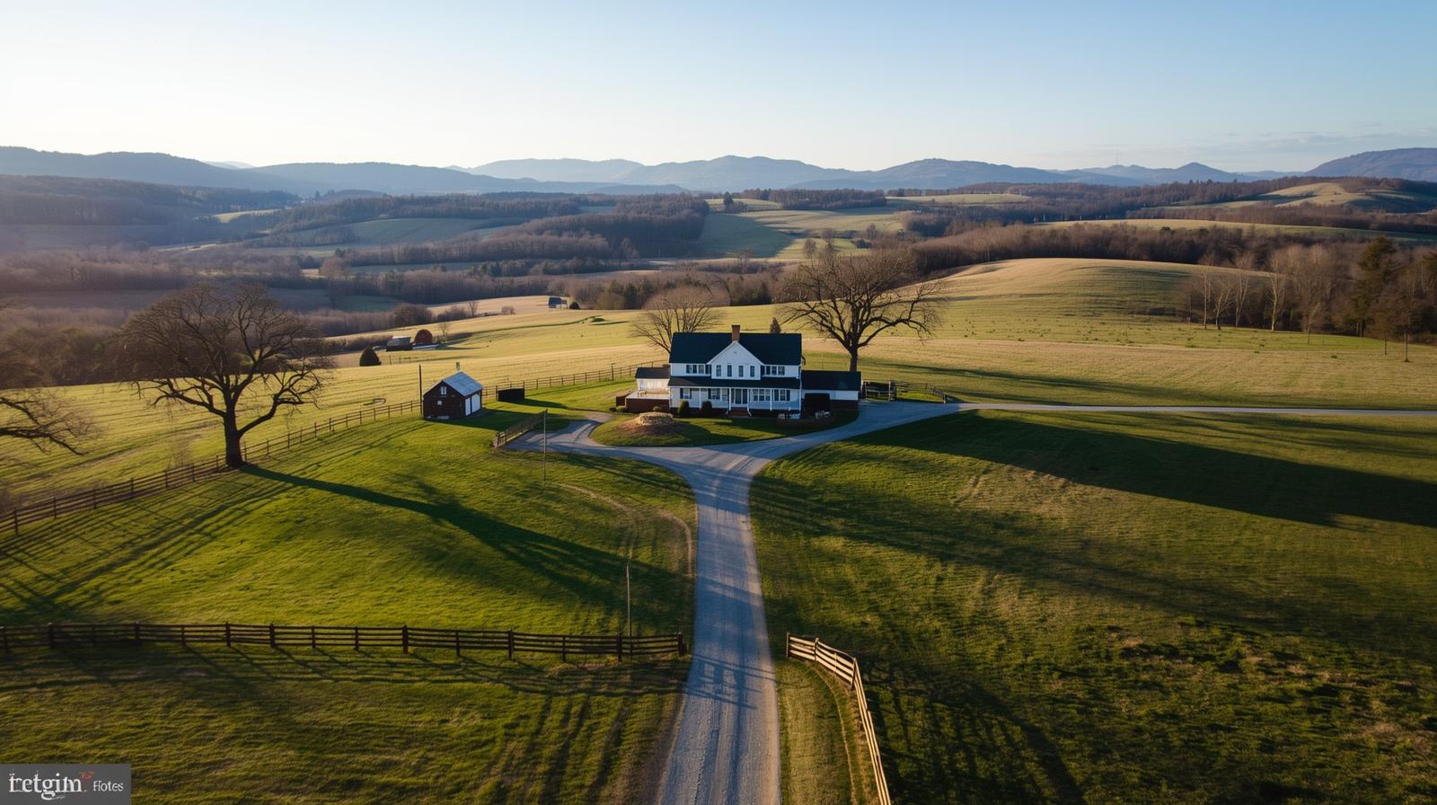 Aerial view of a farmhouse on rolling acreage near Winchester in the Shenandoah Valley with pasture, trees, and mountain views at sunset.